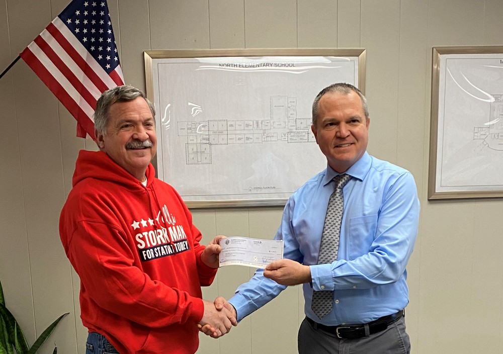 Dan Kieffer presents a donation to District #348 Superintendent Chuck Bleyer